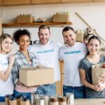 happy-multicultural-women-holding-cardboard-box-and-paper-bag-with-apples-while-standing-near-e1611196039833.jpg